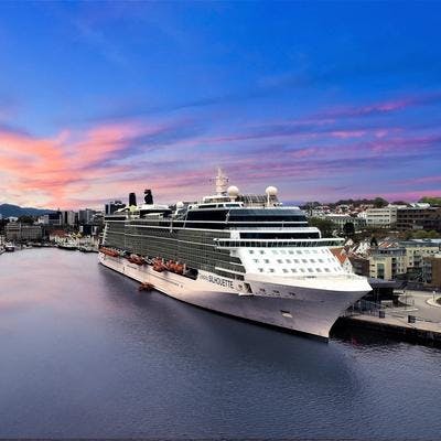 Stort cruiseskip ligger til kai i Stavanger. I bakgrunnen blå himmel med lakserosa makrellskyer.