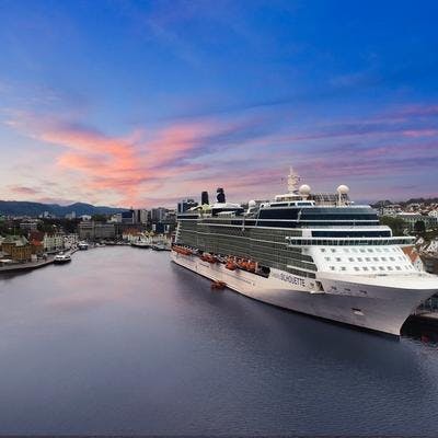 Cruiseskip ligger til kai i Stavanger Havn med lakserosa skyer i bakgrunnen. 