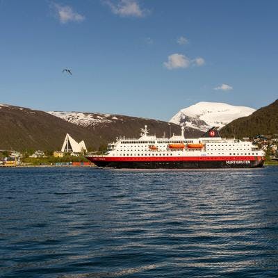 Hurtigruta i fjorden med Ishavskatedralen i bakgrunnen. 